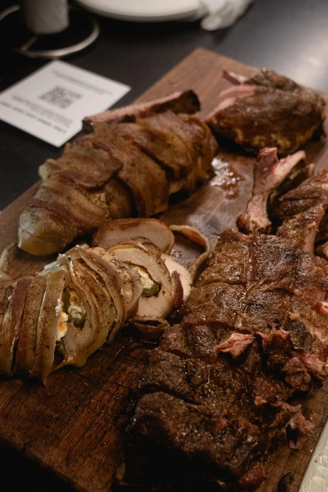 Brisket, pulled pork, and stuffed pork roll filling a serving board.