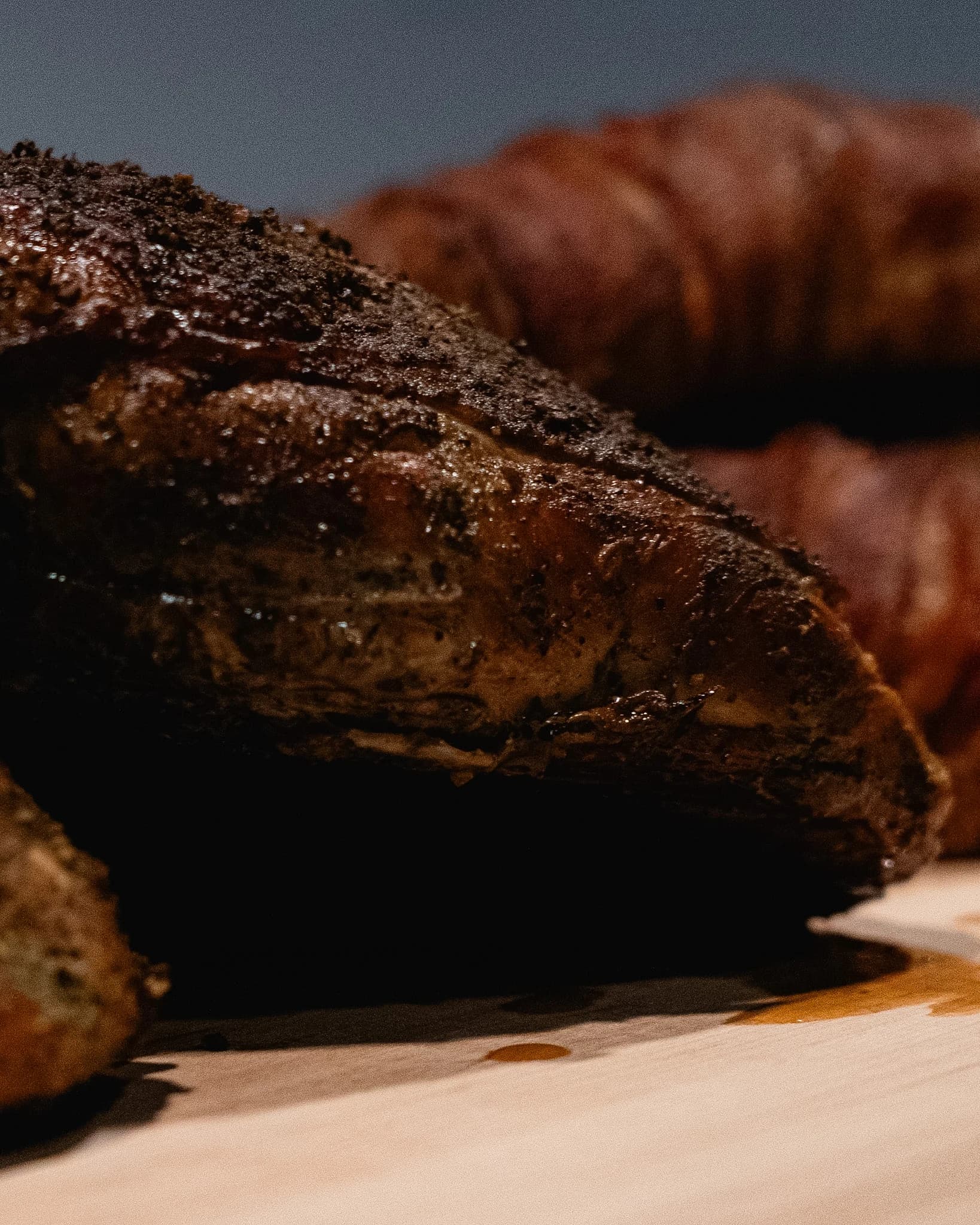 Close view of smoked turkey with a dark seasoned exterior.