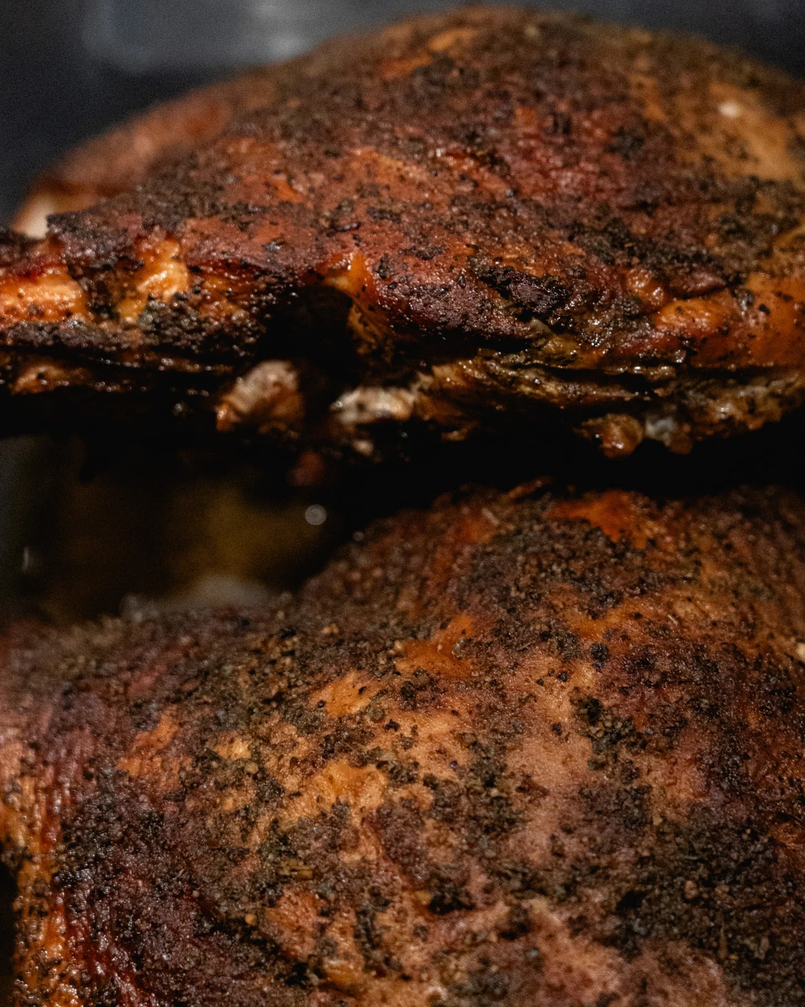 Two portions of smoked turkey stacked with their seasoned exterior visible.