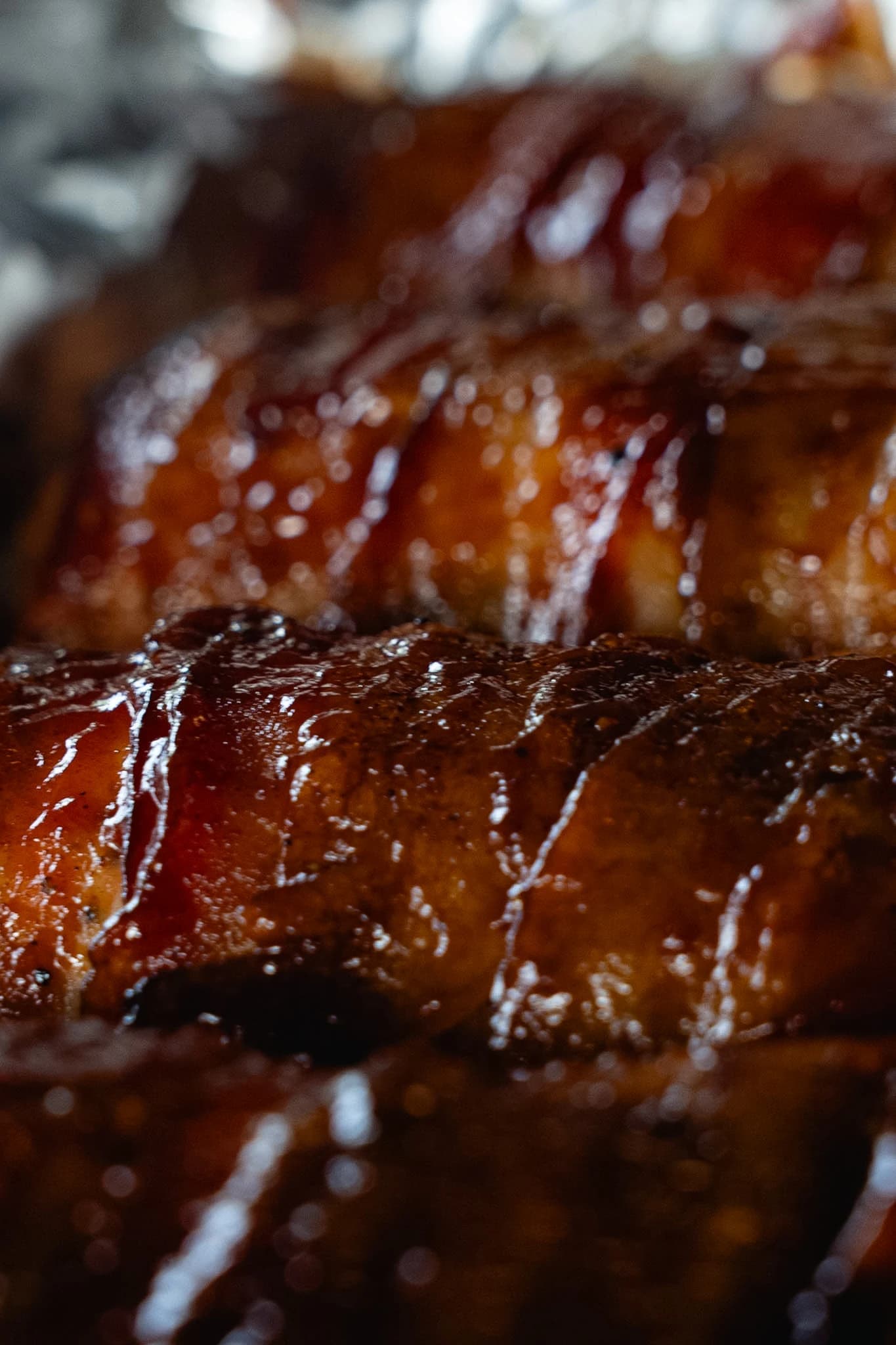 Rows of glazed bacon-wrapped stuffed chicken after smoking.