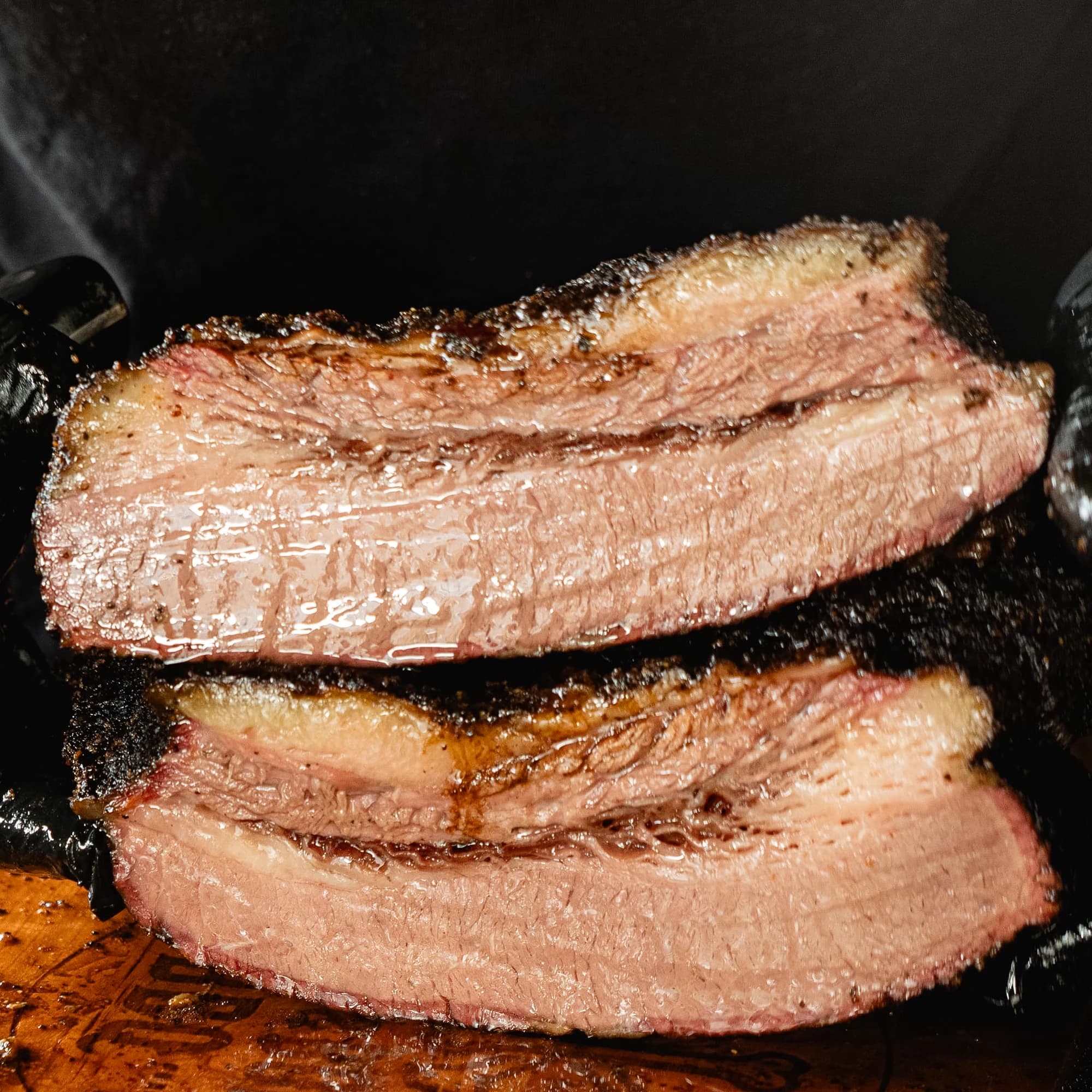 Close square view of sliced smoked brisket with a visible smoke ring.