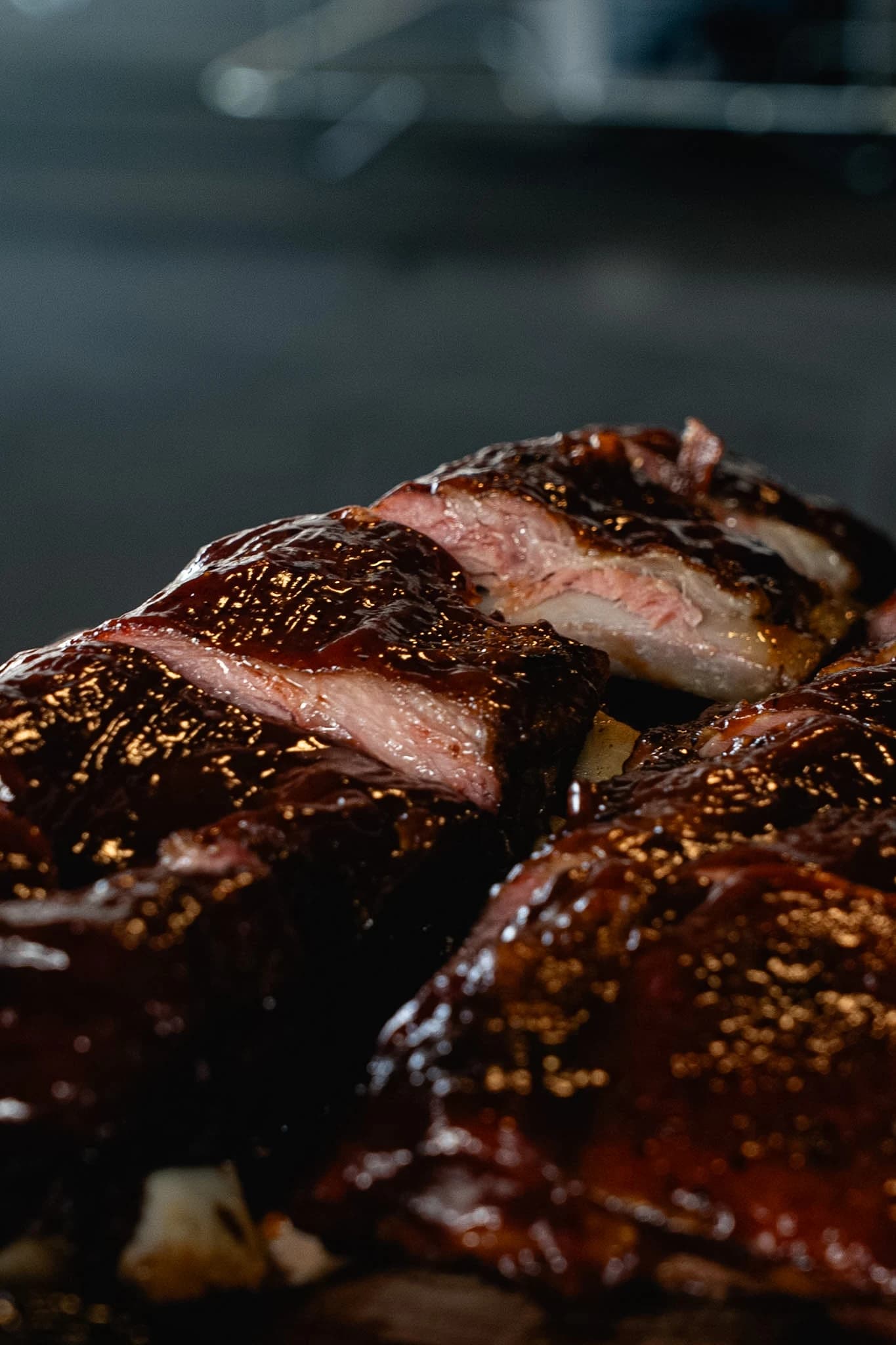 Vertical detail of glazed pork ribs showing the cut edges and smoke ring.