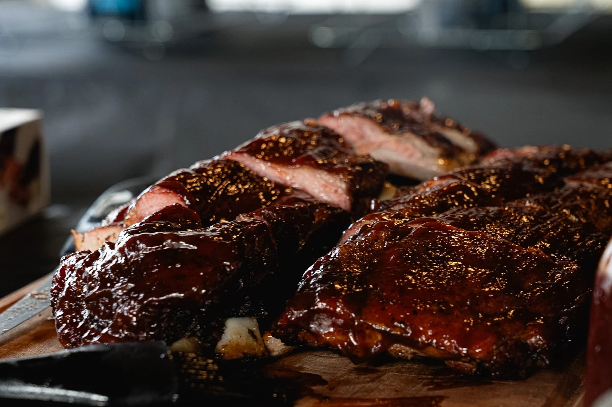 Glazed pork ribs cut into sections and arranged on a carving board.