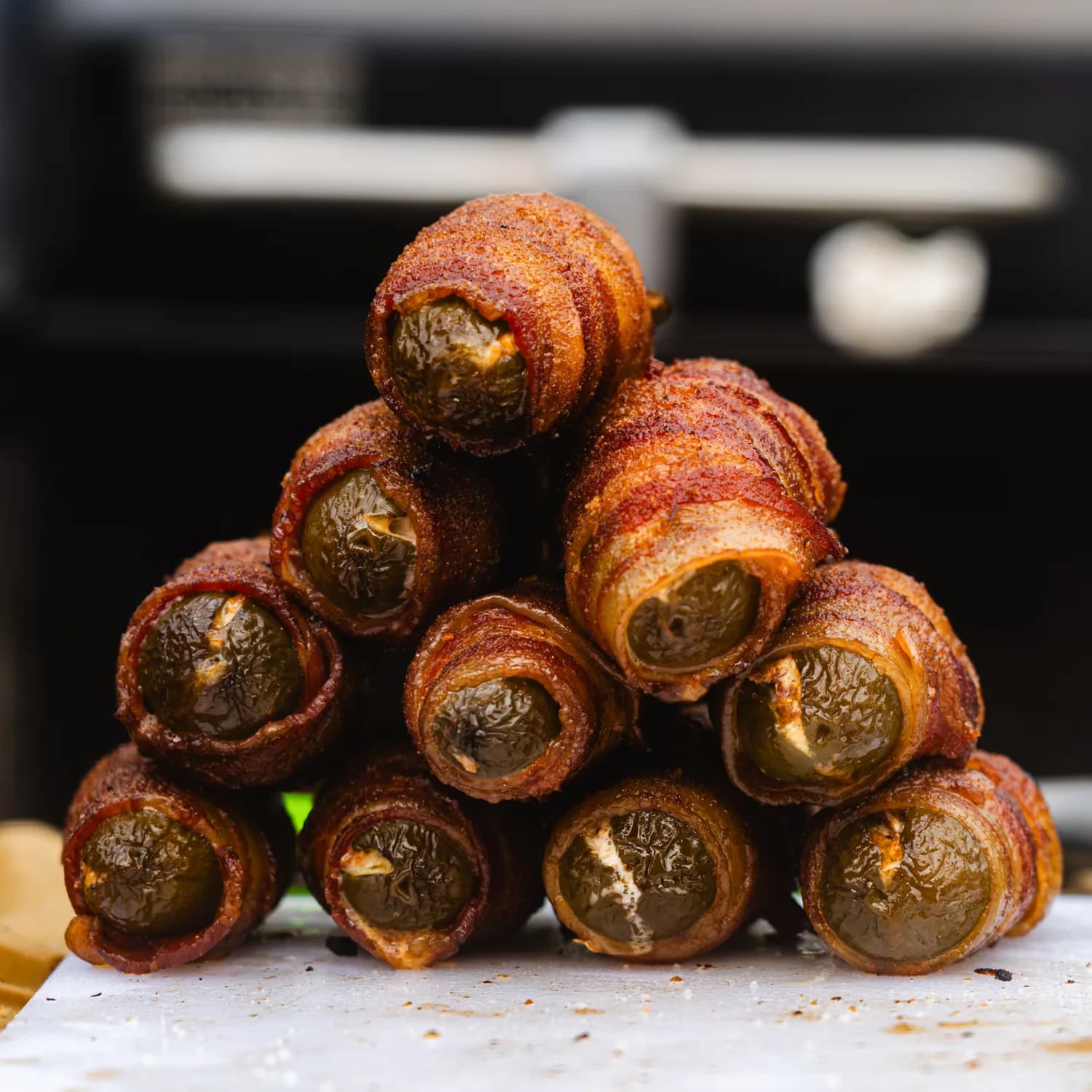 A pyramid of bacon-wrapped stuffed jalapeños fresh from the smoker.